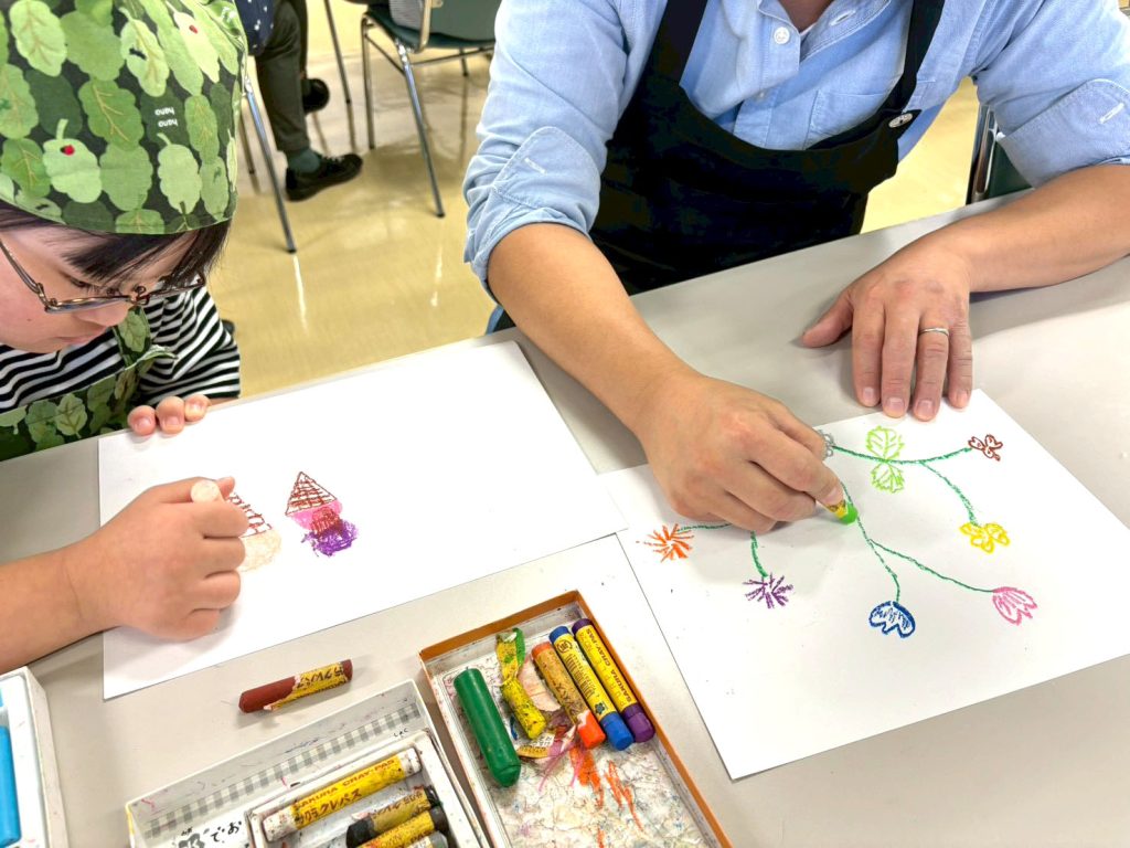 こうじ作りを体験して絵を描く子供とお父さん